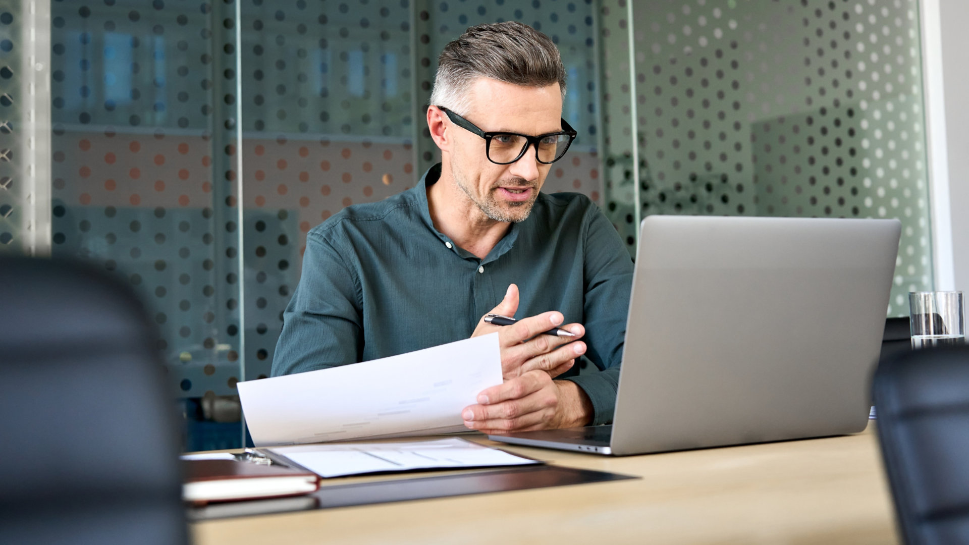 A man on a laptop in a meeting room