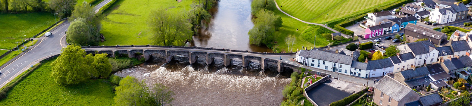 Aerial view of an old bridge across a fast flowing river (River Usk, Crickhowell, Wales)