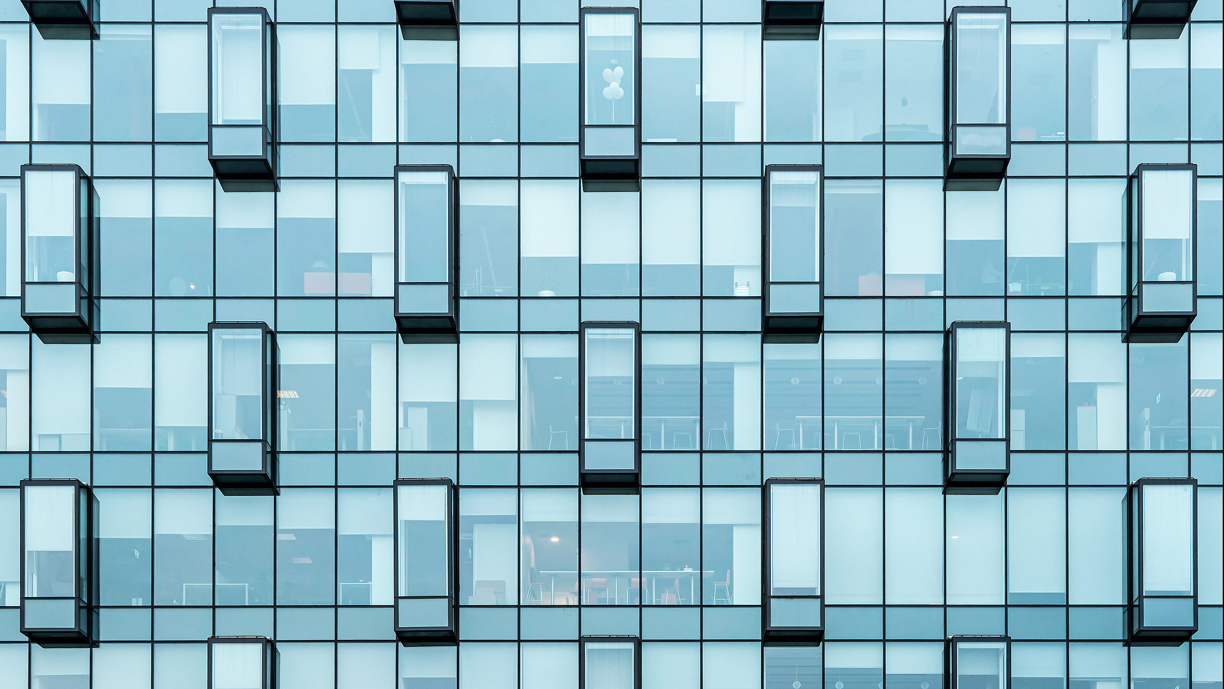 Photo of an office building façade with glass windows 