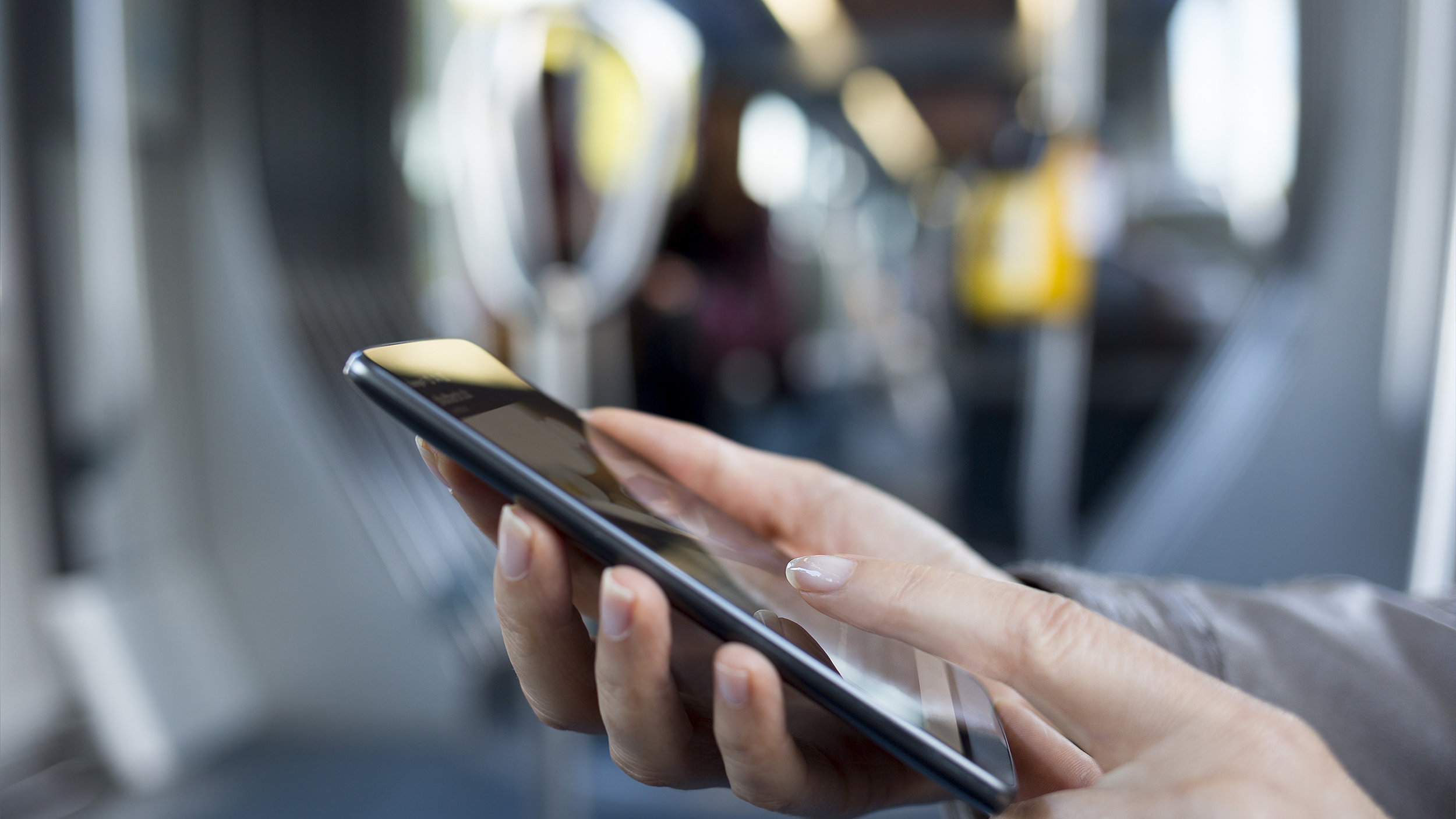 Woman using phone in carriage on Tube