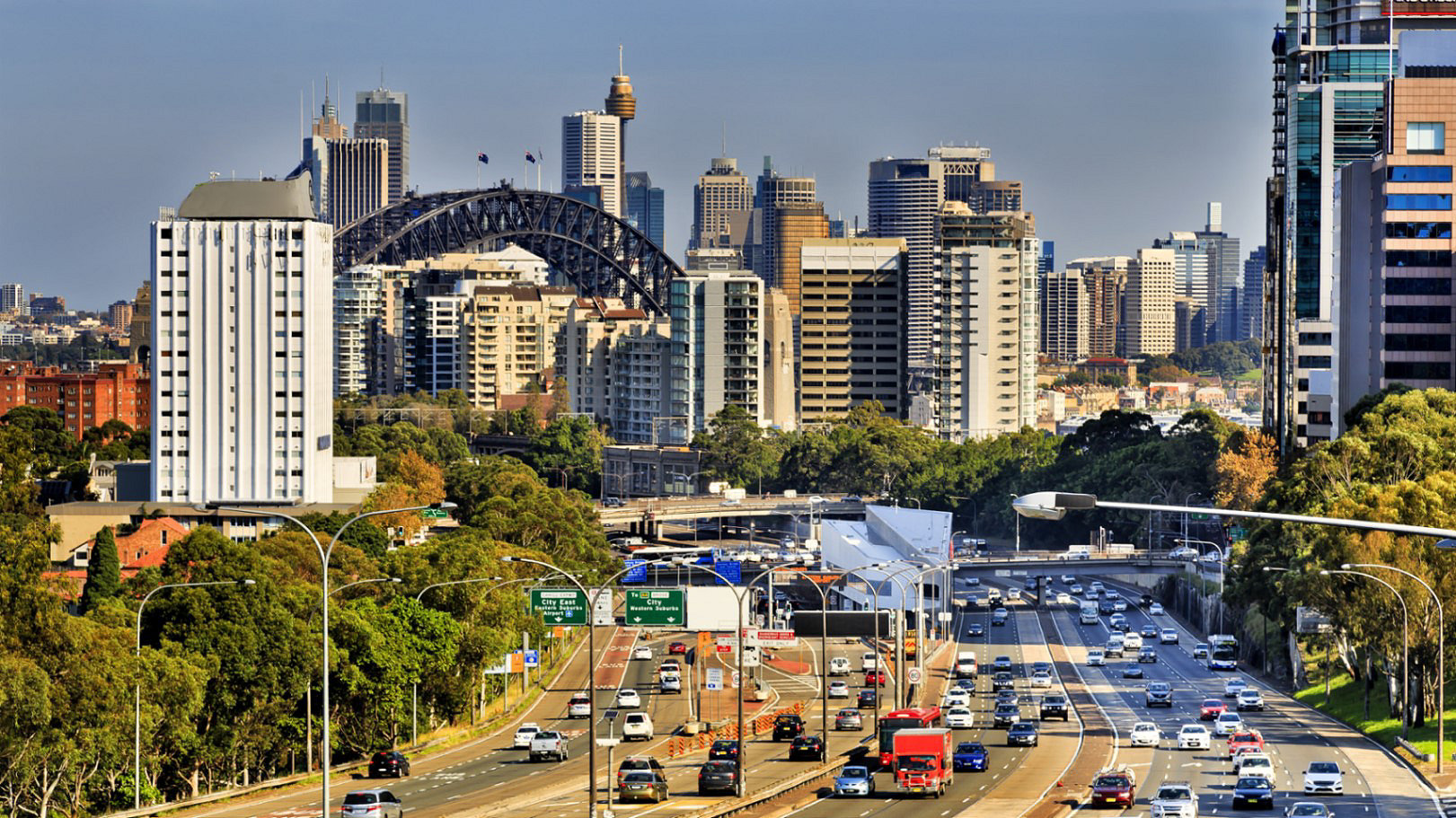 Cars on a motorway during rush hour in Sydney, Australia with high rise buildings in the background