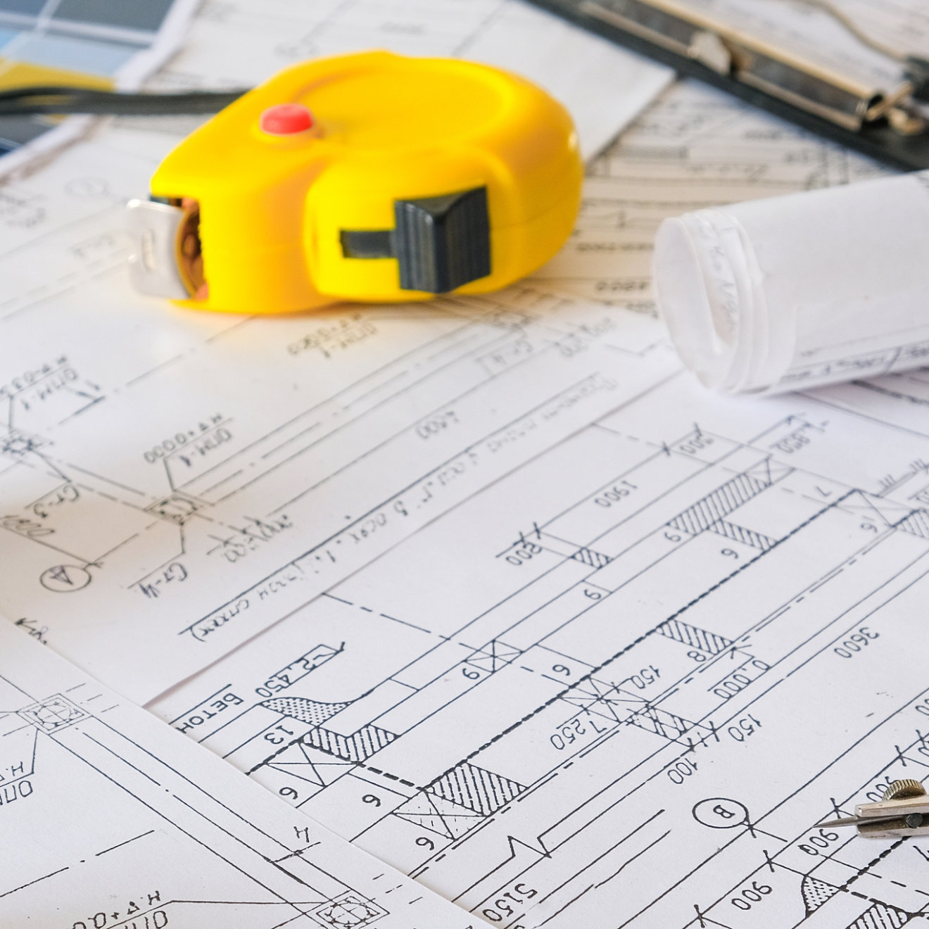 Blueprints on table with tape measure