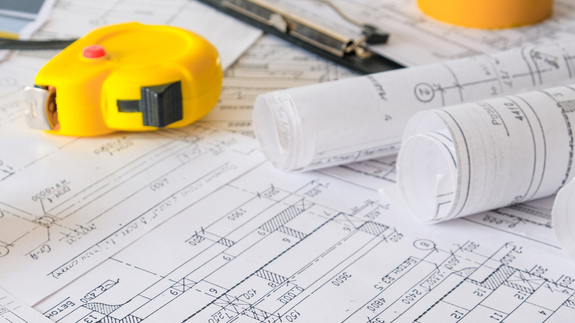 Blueprints on table with tape measure