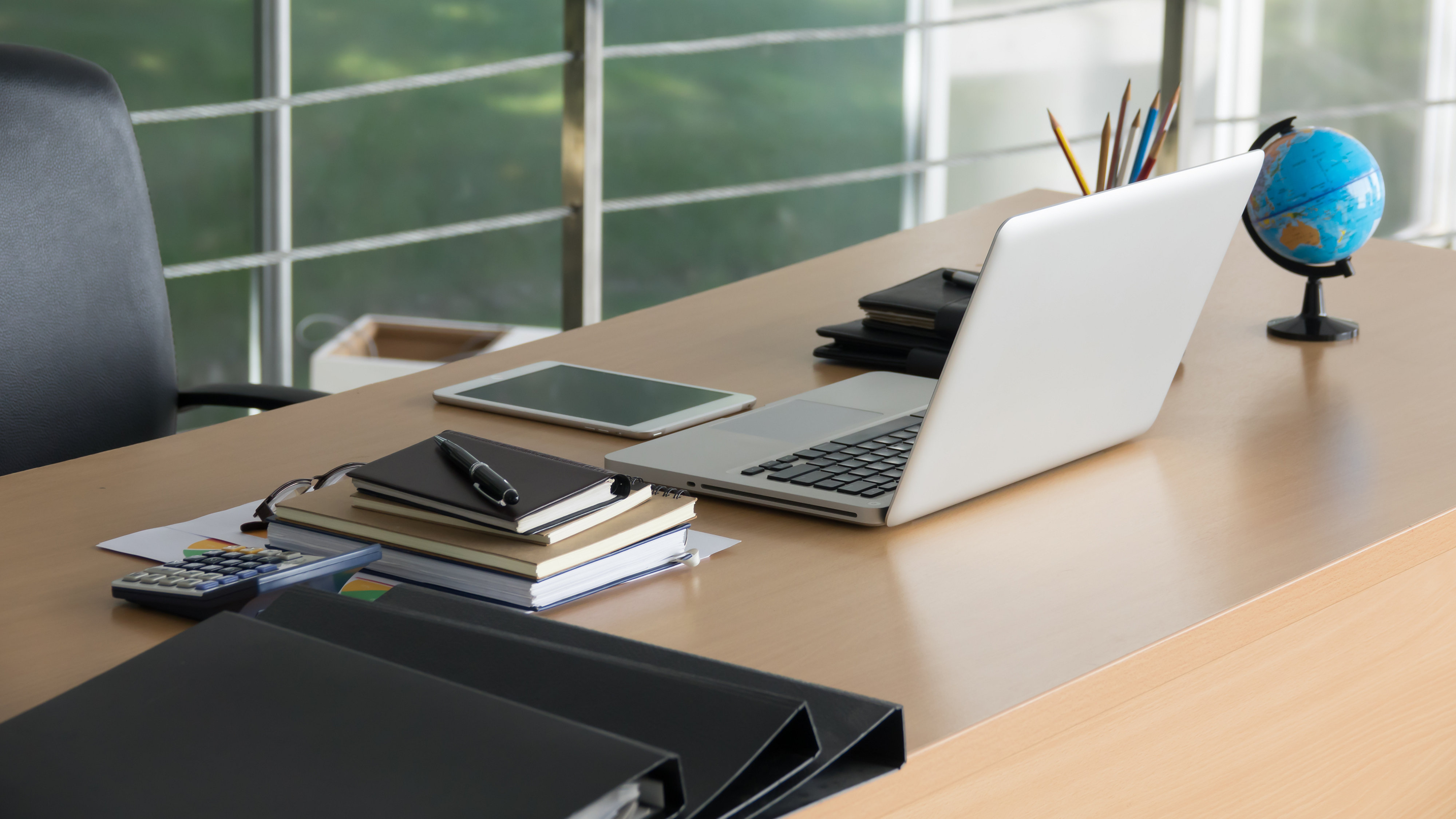 Business office table with laptop earth model on wooden table.