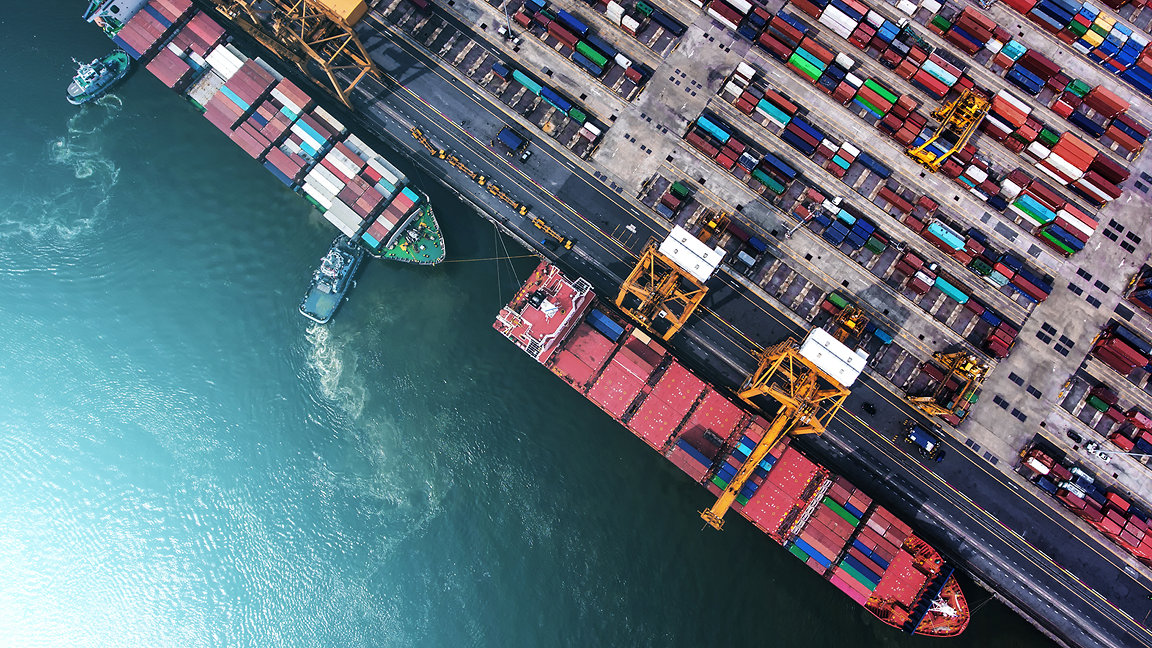 overhead shot of a shipping port and two ships unloading containers