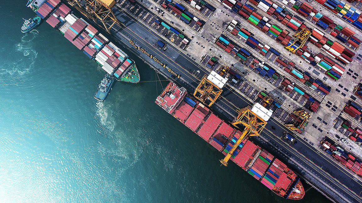 overhead shot of a shipping port and two ships unloading containers