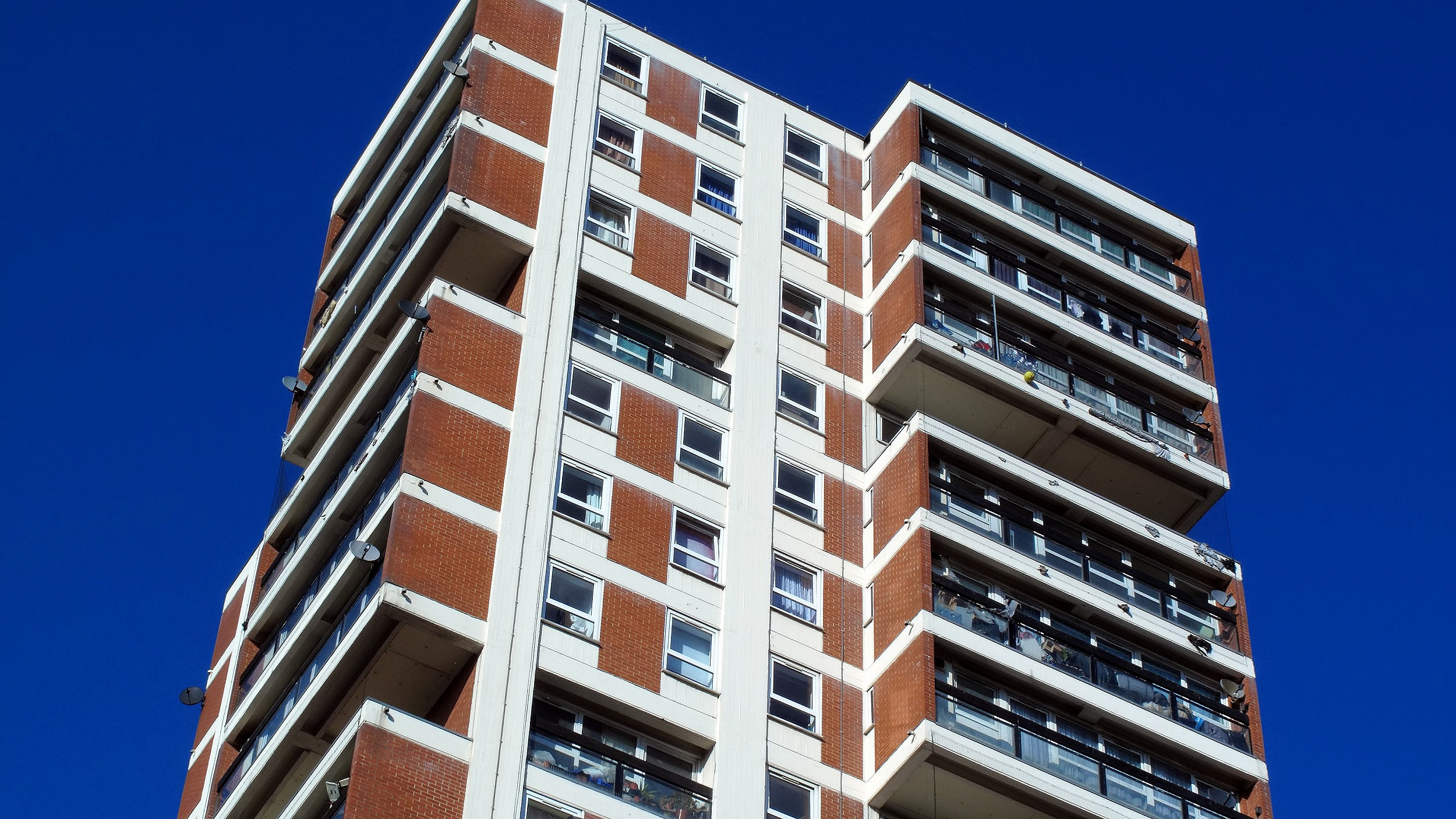 High-rise block against blue sky background