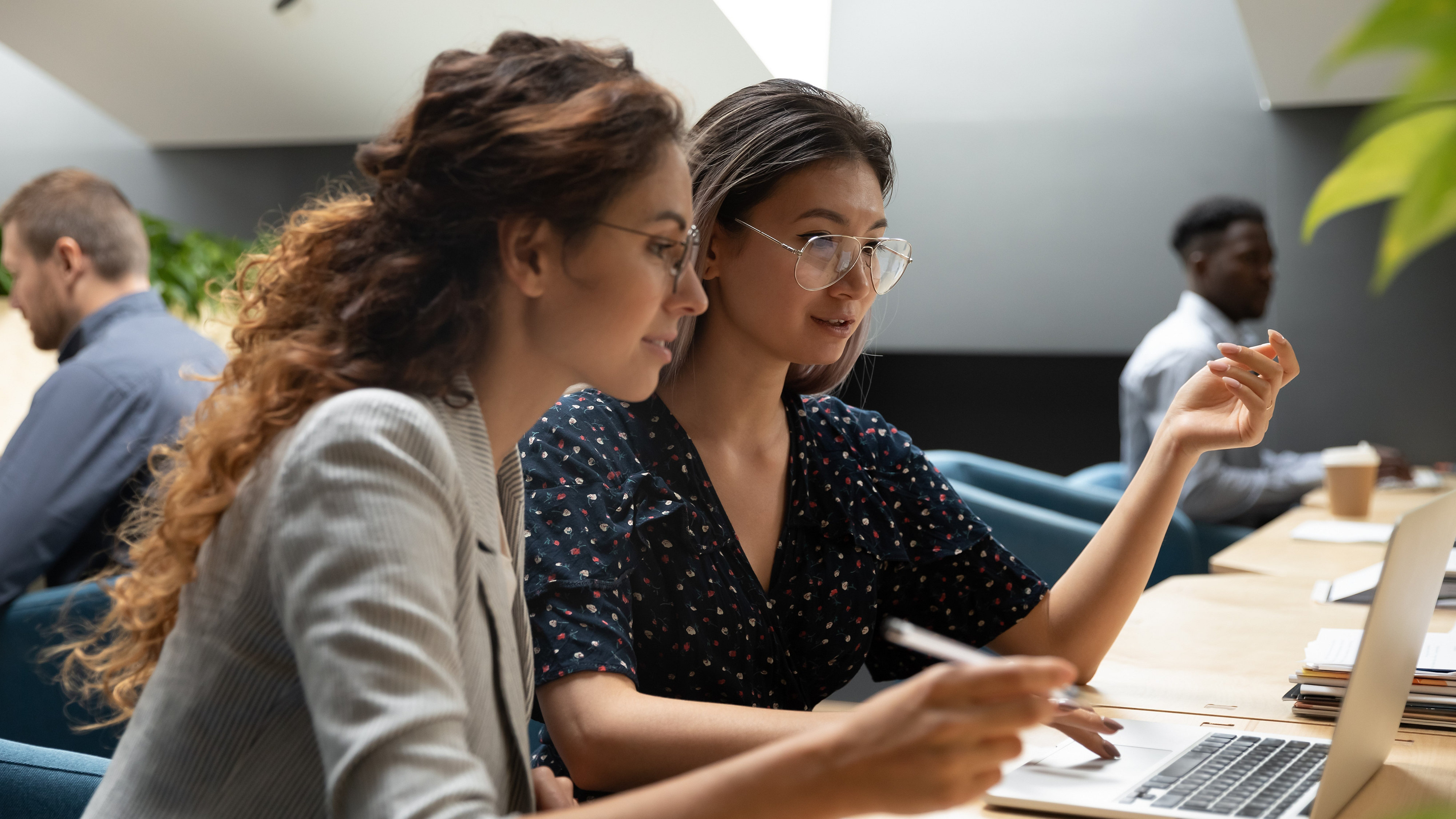 Asian woman mentoring younger white woman