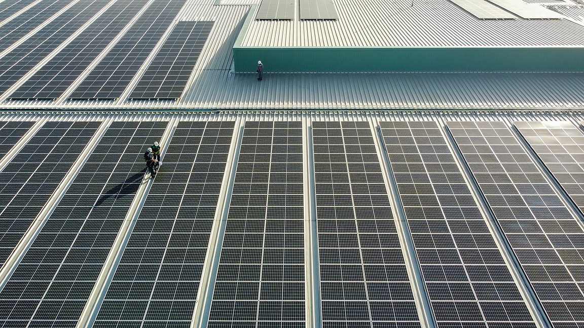 Solar panels installed on a roof of a large industrial building or a warehouse