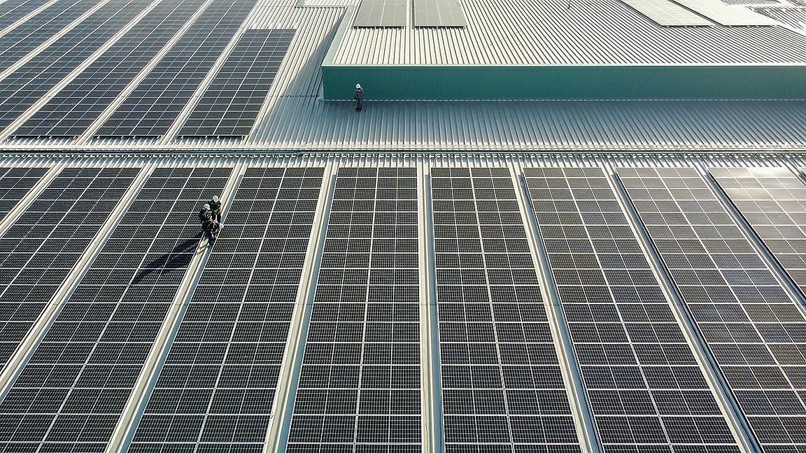 Solar panels installed on a roof of a large industrial building or a warehouse