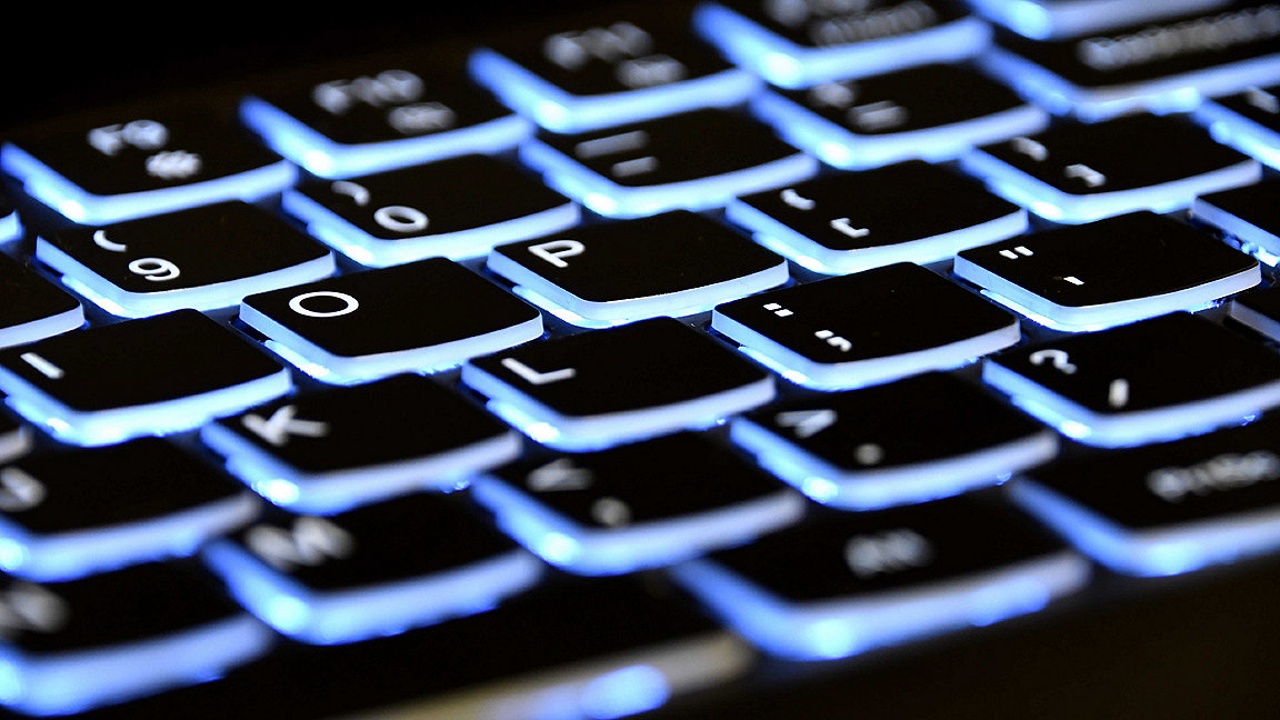 A close up of black computer keys with blue backlighting