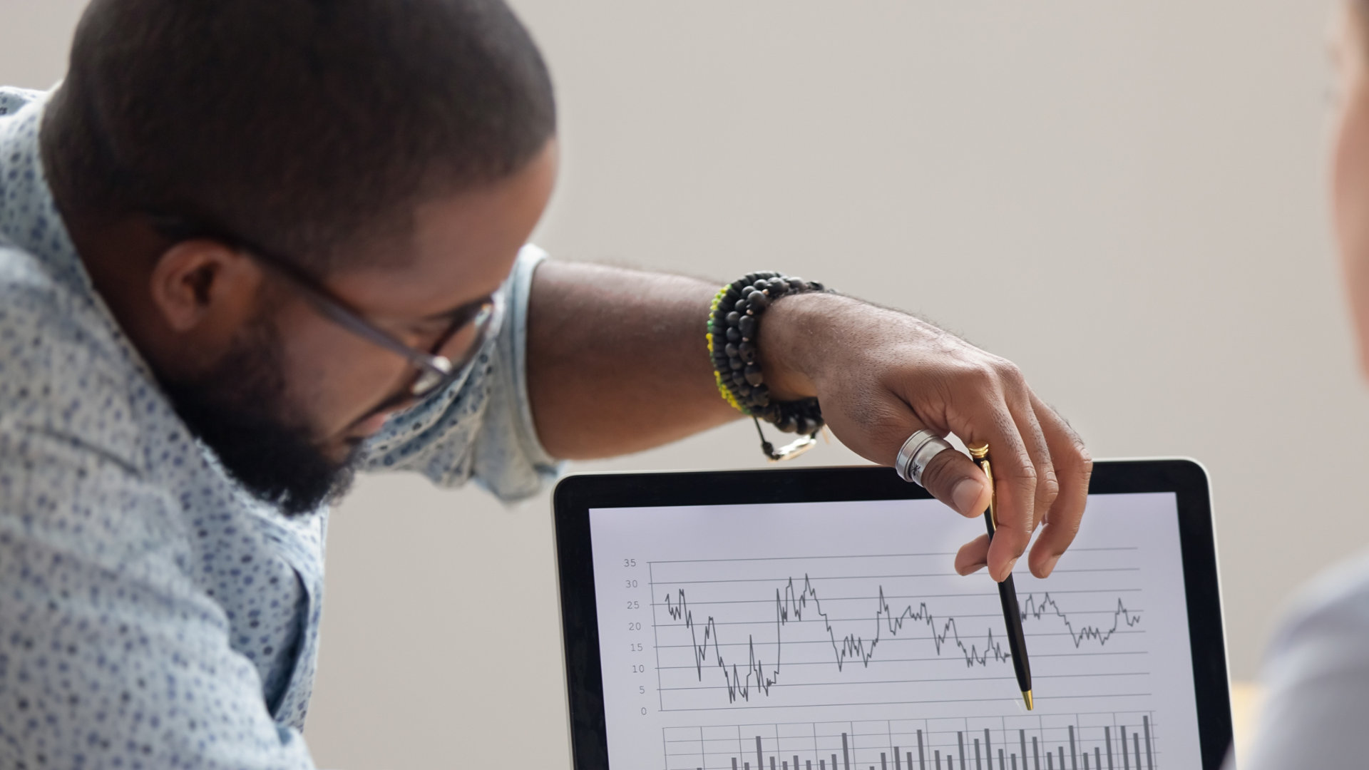 Focused african analyst showing client or colleague annual financial report analyzing business data on laptop screen using software for digital graphic statistic analysis, economic market graphs ; Shutterstock ID 1368244205; Purchase Order: N/A