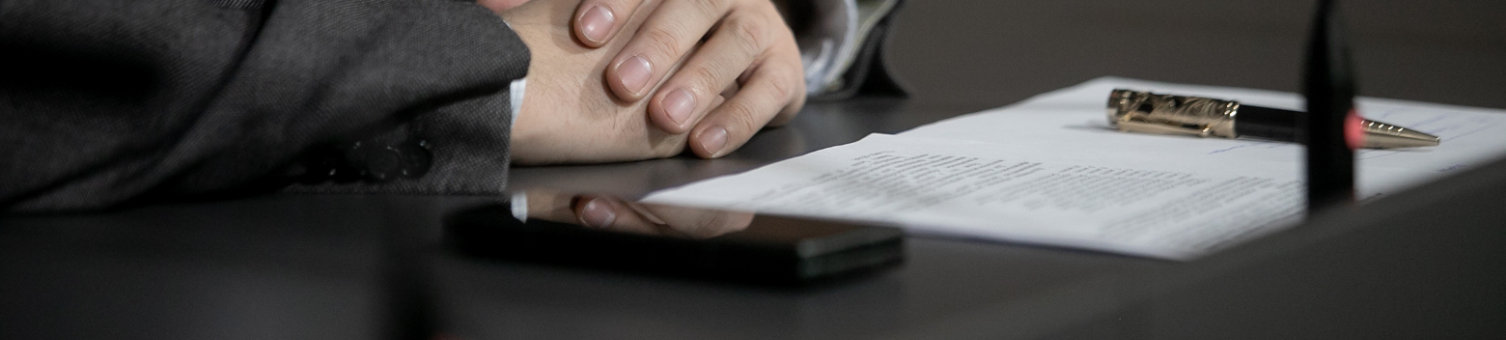 Hands of an official, speaker or boss during a press conference - meeting with the press. Speaker at the talks. Blank plate to indicate the name and position. Close-up. No face; Shutterstock ID 2123647583; purchase_order: N/A; job: RICS DRS Image Update Feb25; client: RICS_PP; other: 