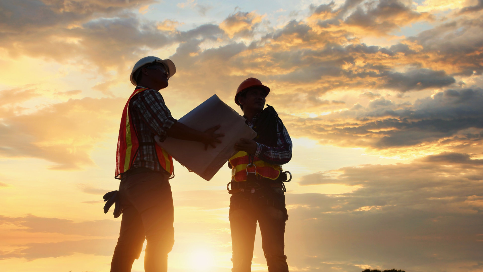 Construction workers working at sunset