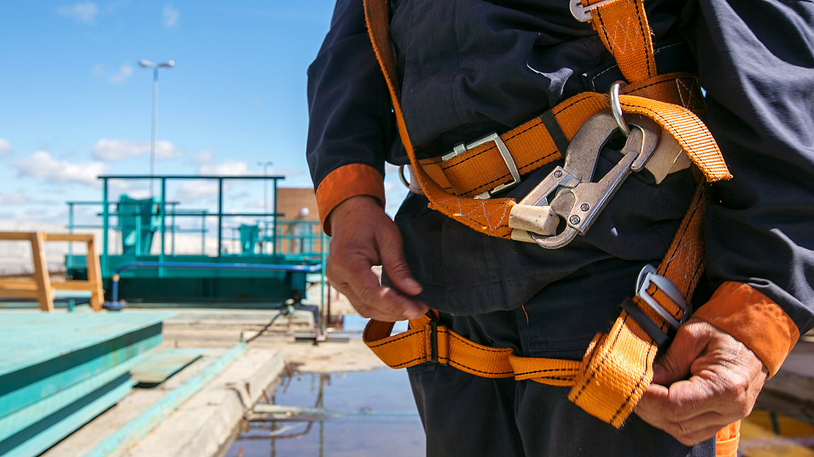 close up of a construction worker wearing safety harness for working at height