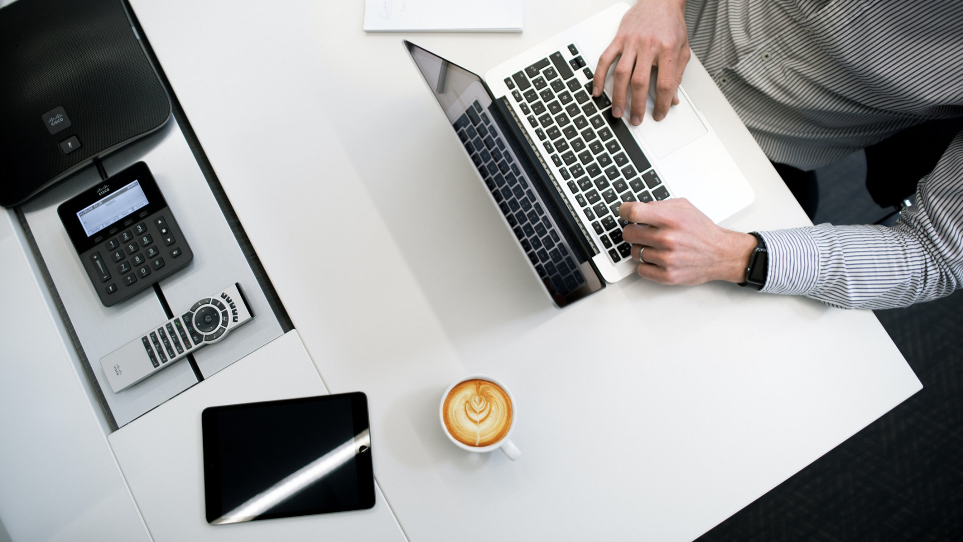 Overhead view of man working on his laptop sat at his desk