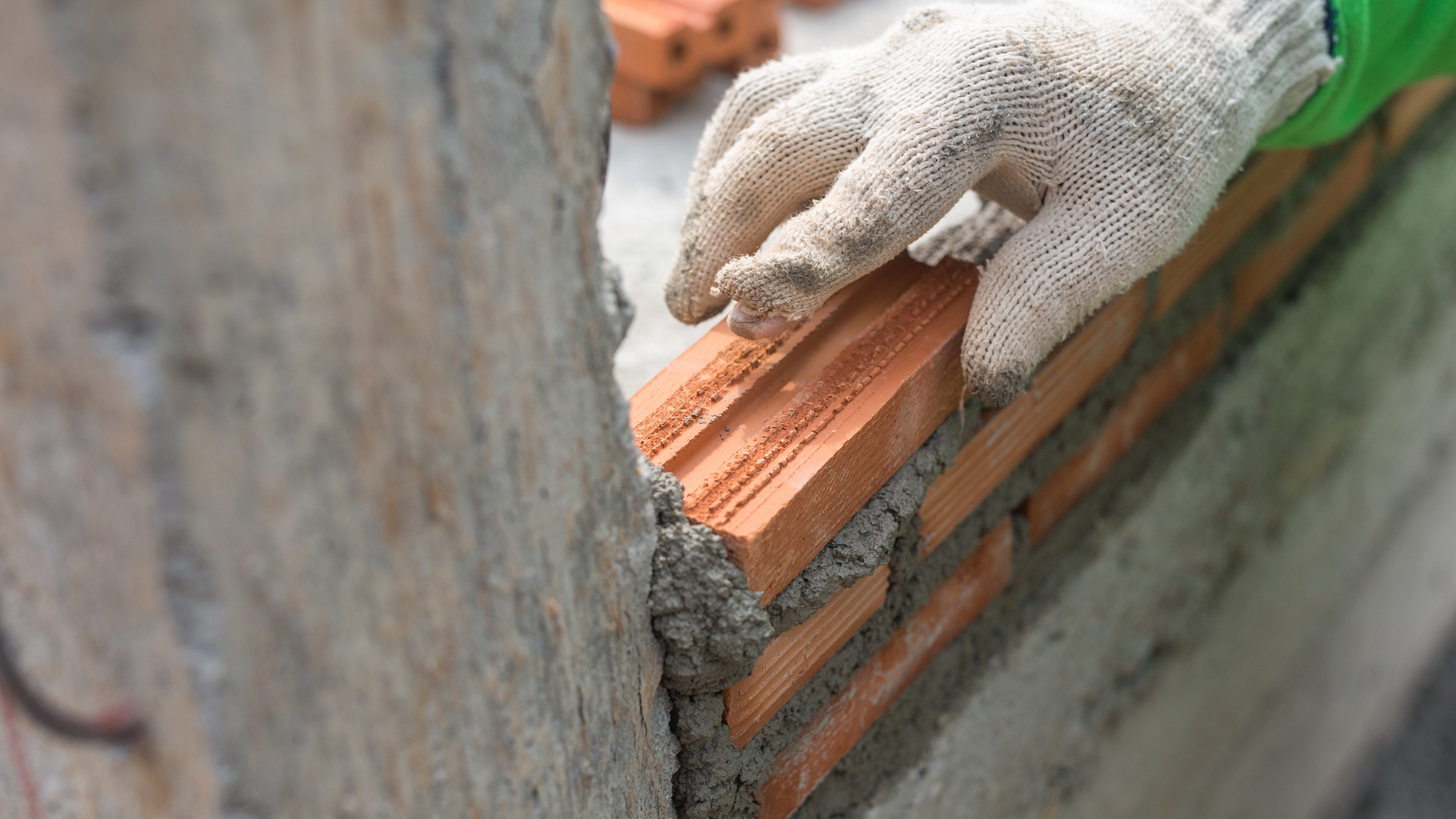 Close up on hand laying bricks