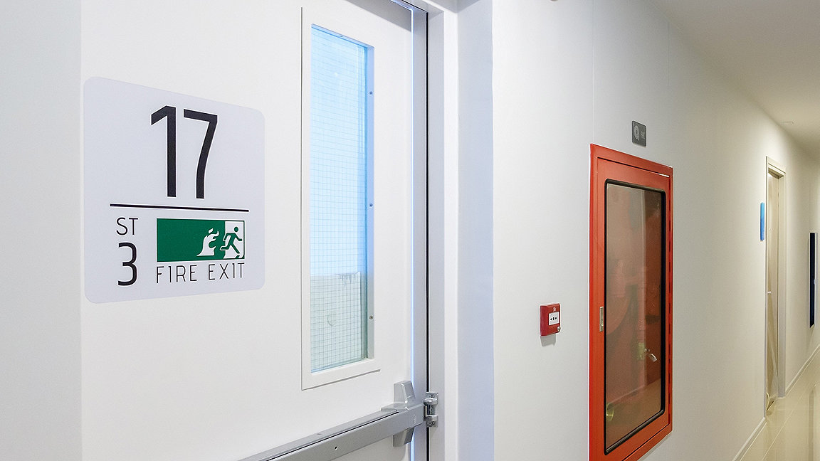 Fire extinguisher system on wall with fire exit door 