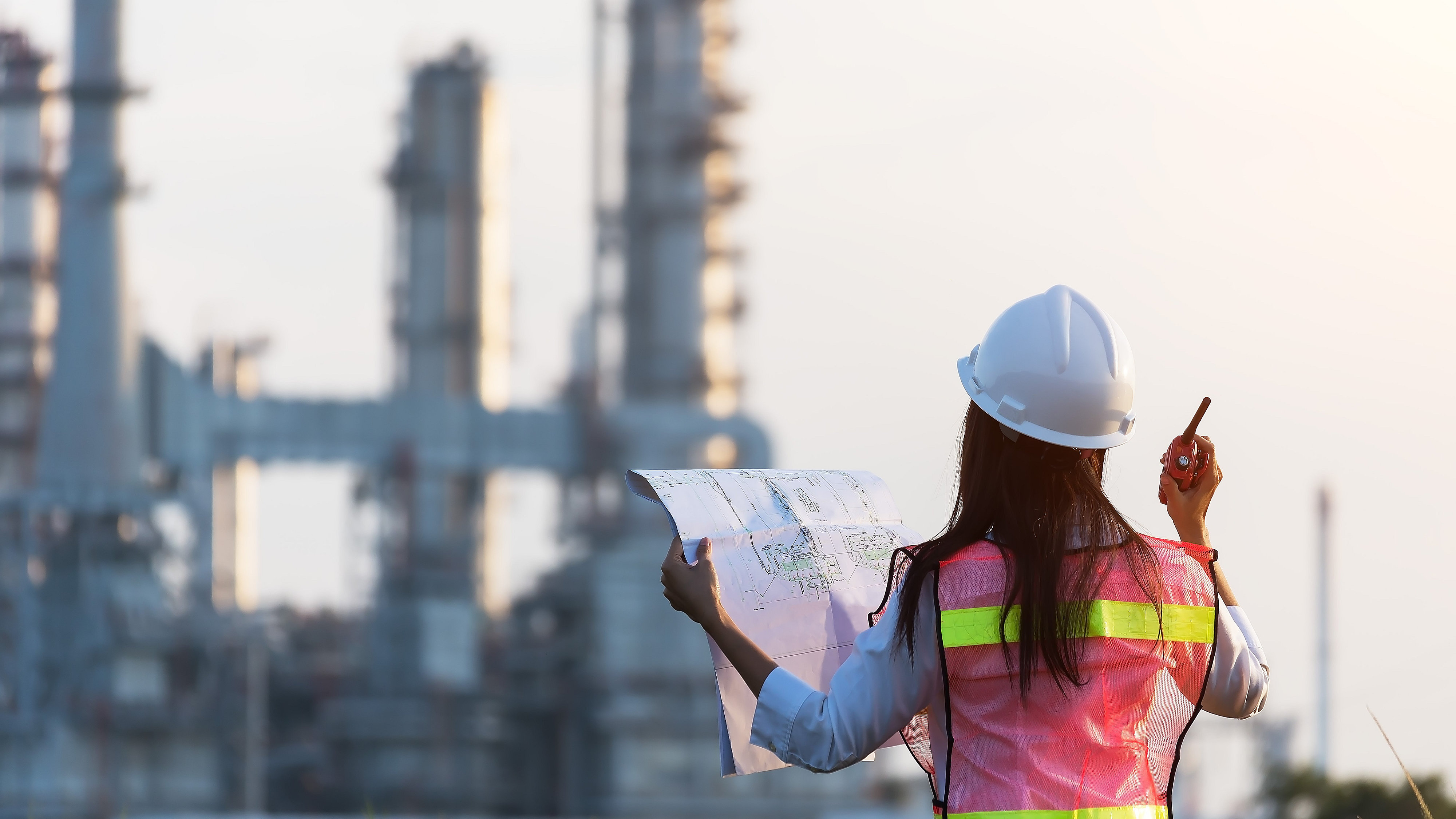 Black female construction worker in front of industrial site