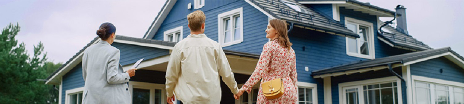 A couple standing in front of a blue house