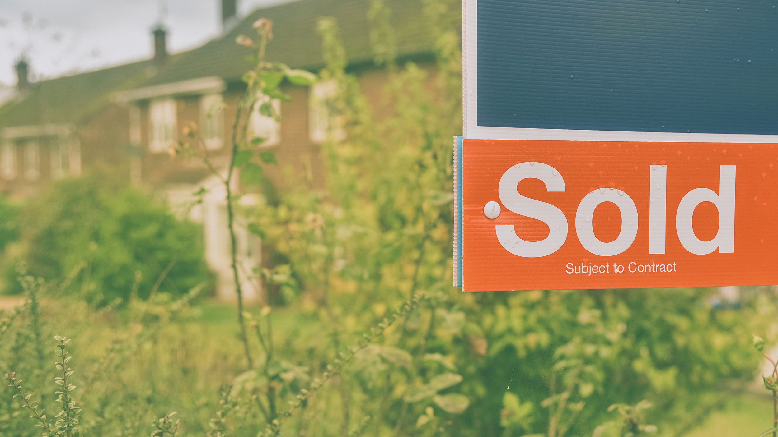 Sold sign houses in background