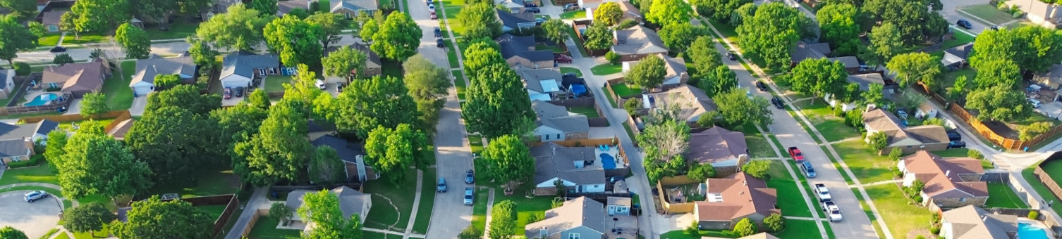 Parallel residential streets with back alleys and row of single-family houses surrounding by lush green trees in suburbs Dallas Fort Worth metro complex, suburban homes swimming pool, aerial. USA