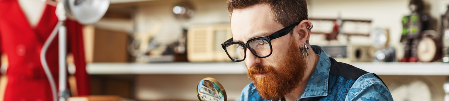 Man inspecting object with a magnifying glass