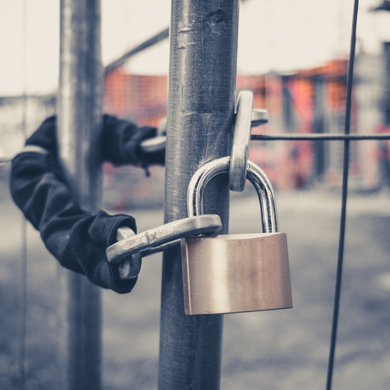 chain and padlock on gate at construction site - lock on closed fence