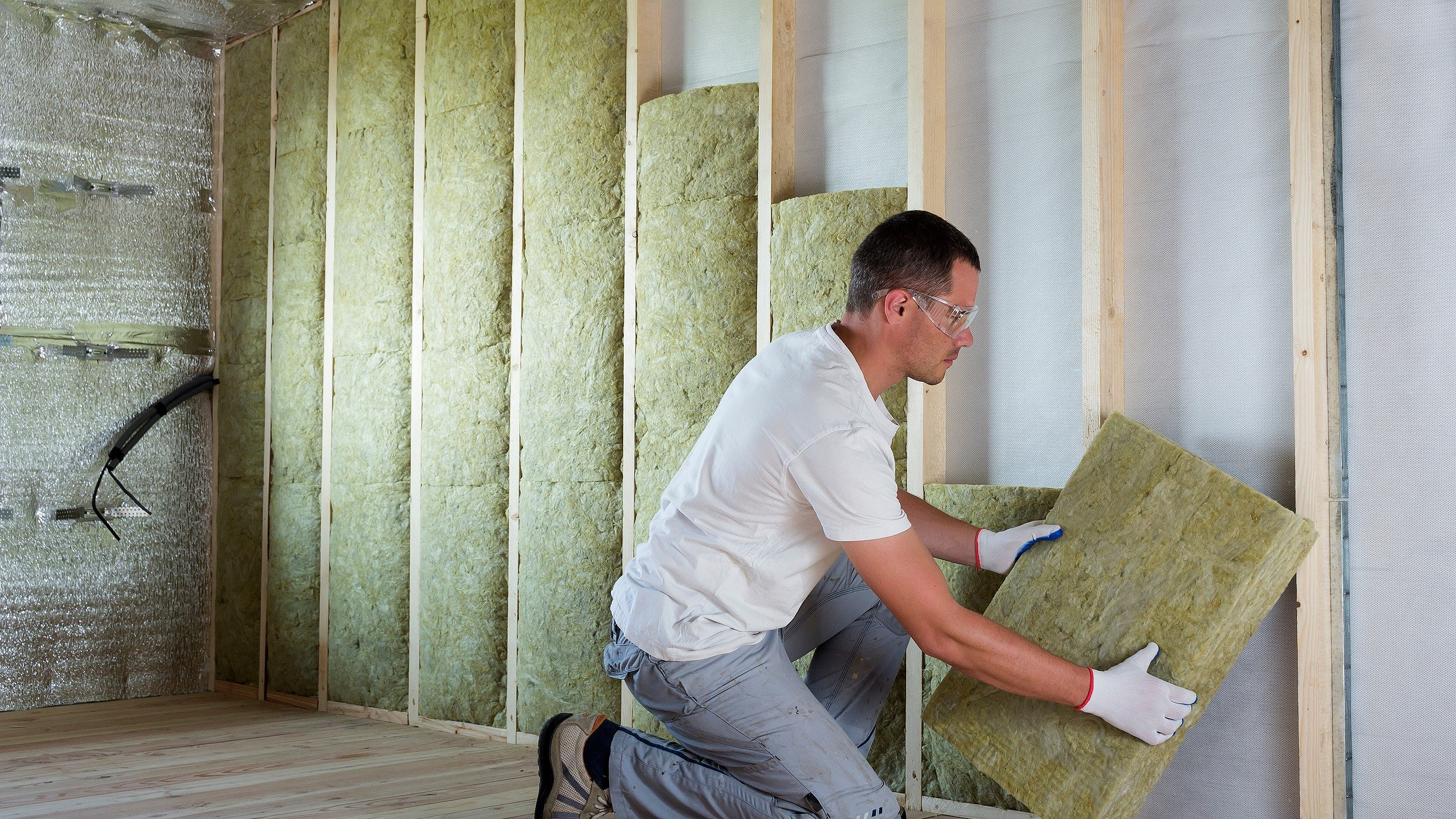 Man installing material in a loft