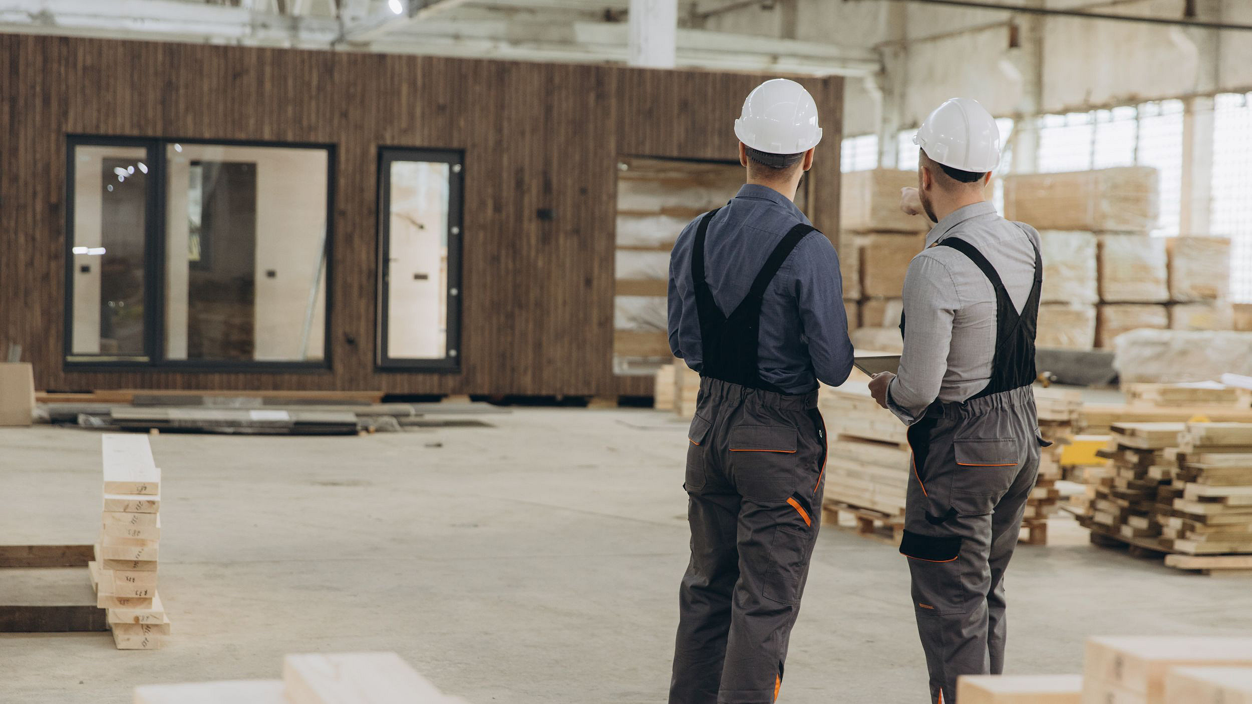 two construction workers inspecting work in MMC factory