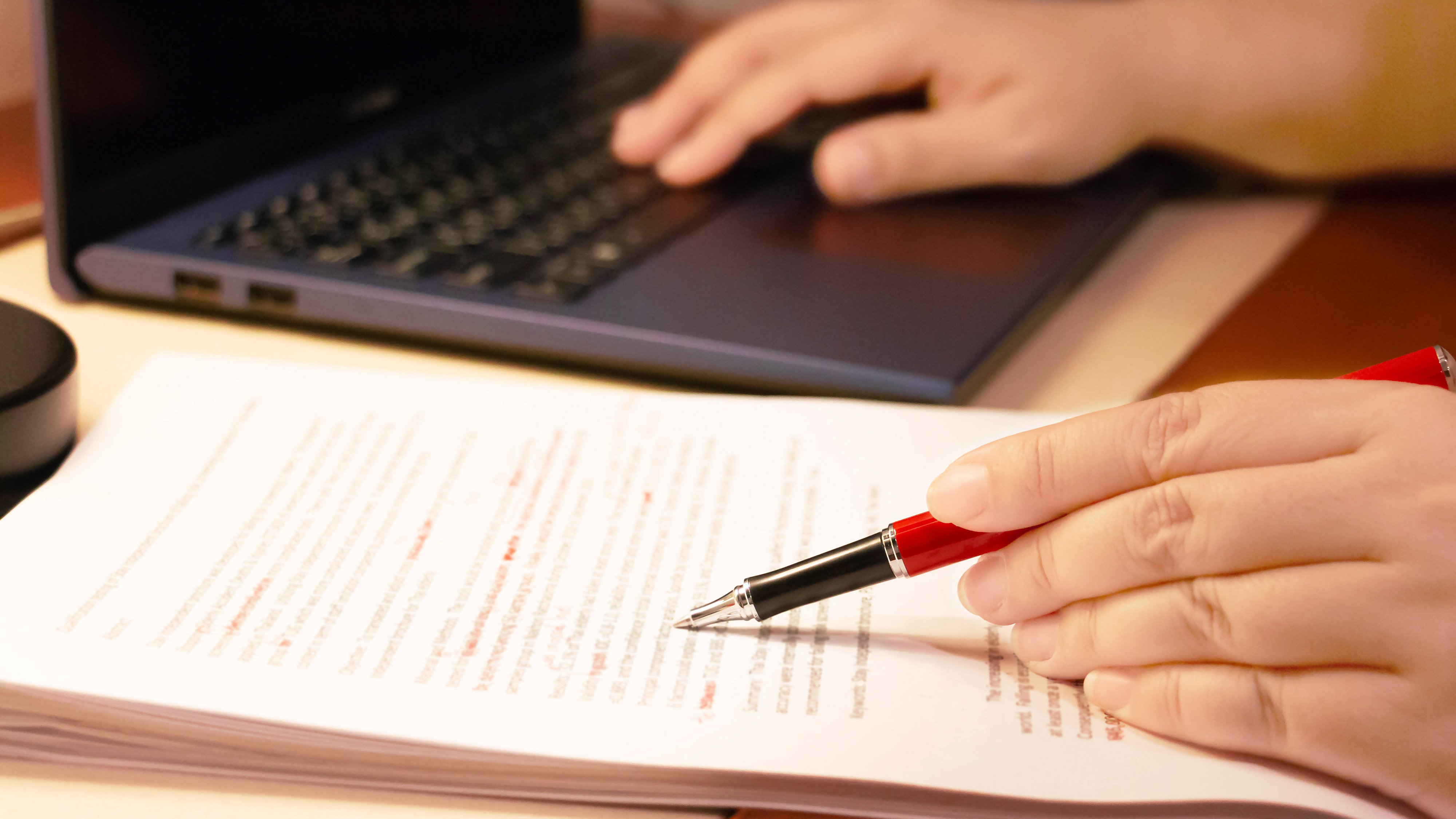 Close-up of hand holding pen over document