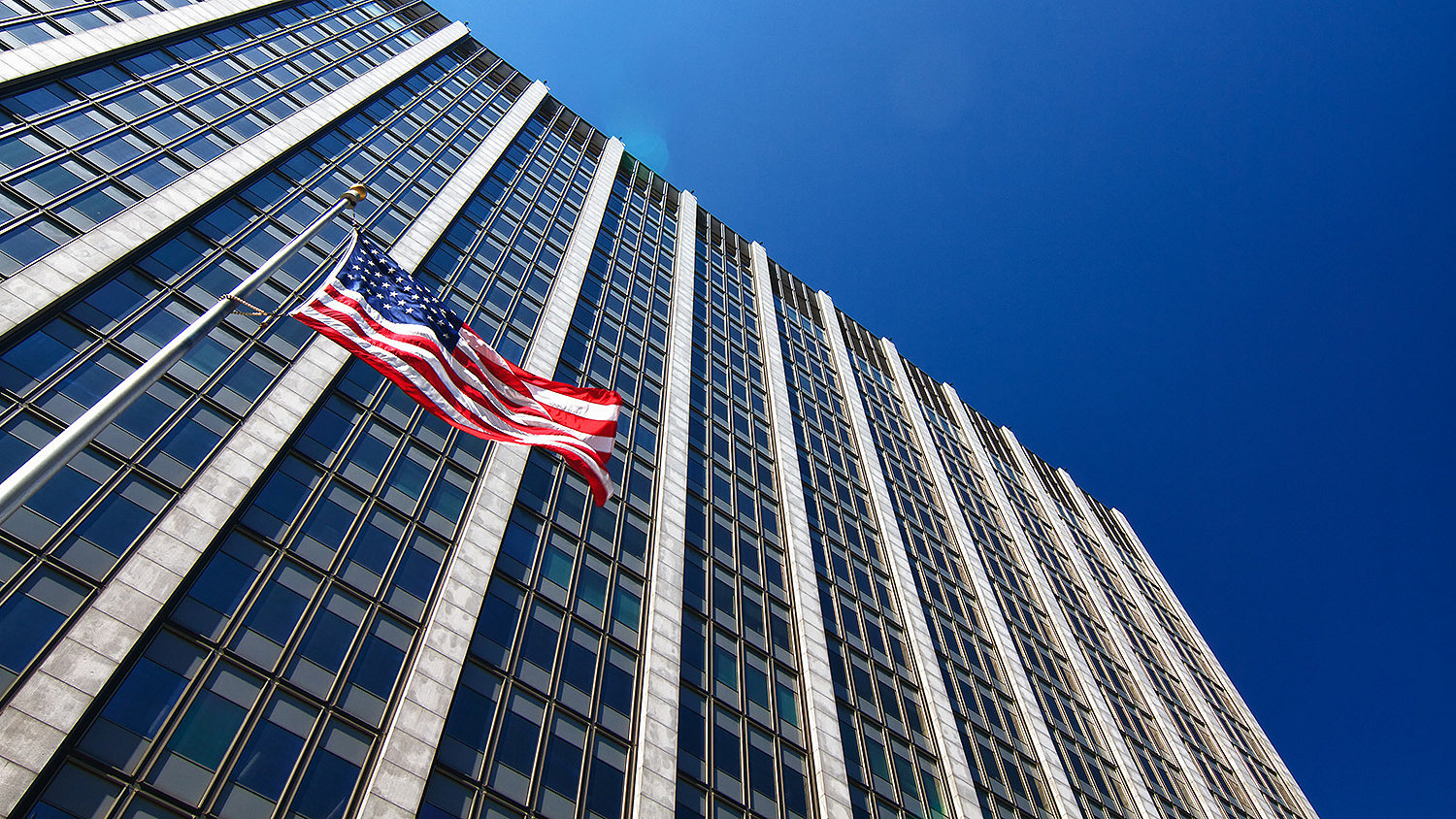 Photograph of US office building with a US flag