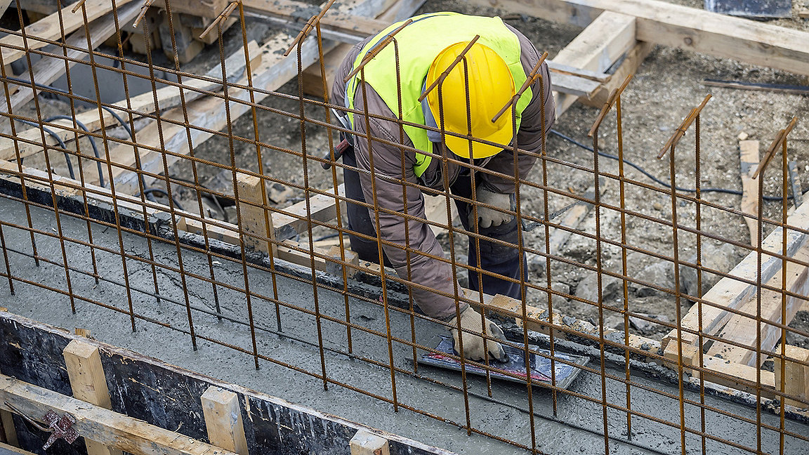 overhead shot of construction worker spreading cement