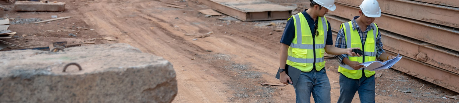 Two construction workers walking through a construction site