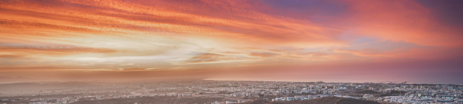 A sunset over a town with a winding road