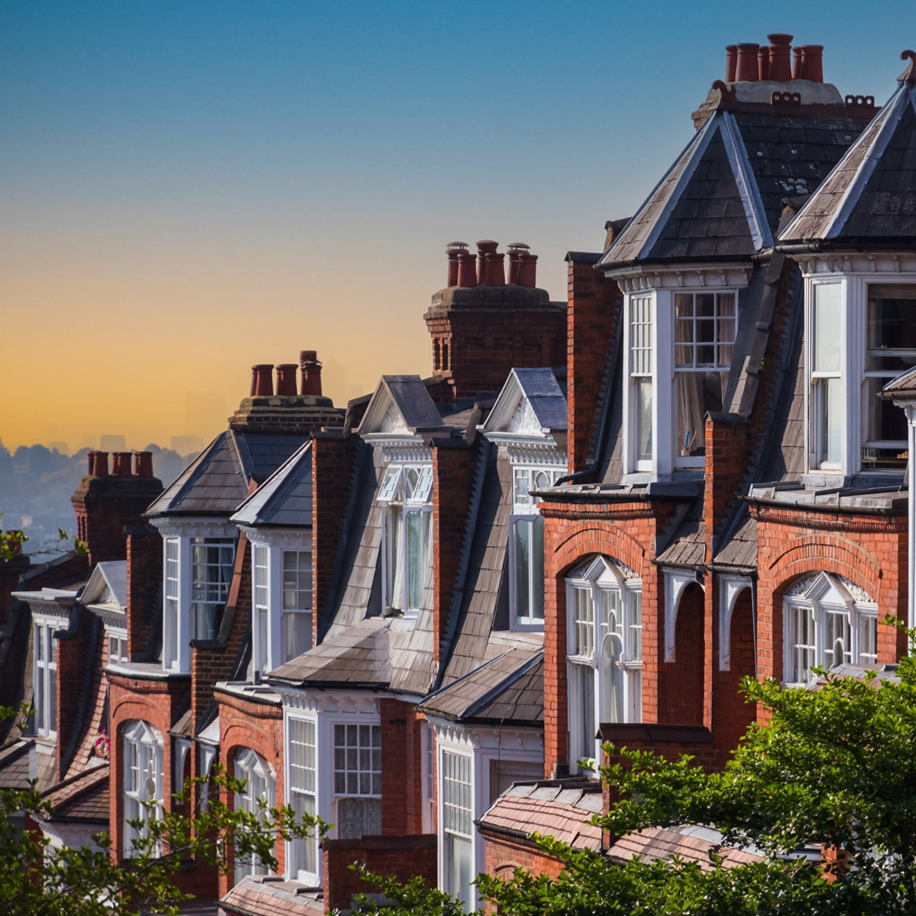 Row of traditional English terraced houses in Muswell Hill during sunset in London, England