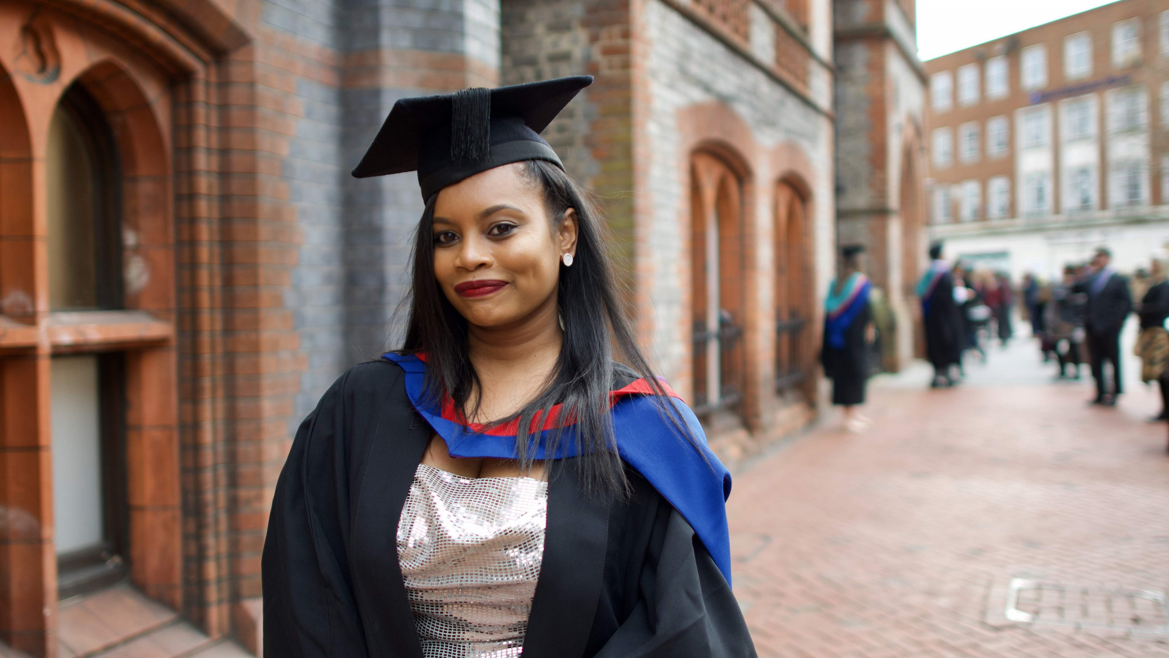 Young Asian woman wearing graduate gown