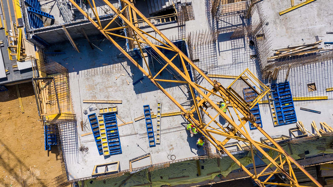 Aerial view of a building site looking down through a crane's arm