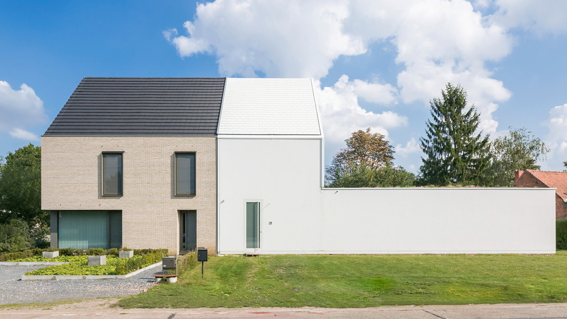 House split in two sections. Left hand side beige with windows and the right side white plain plasterboard