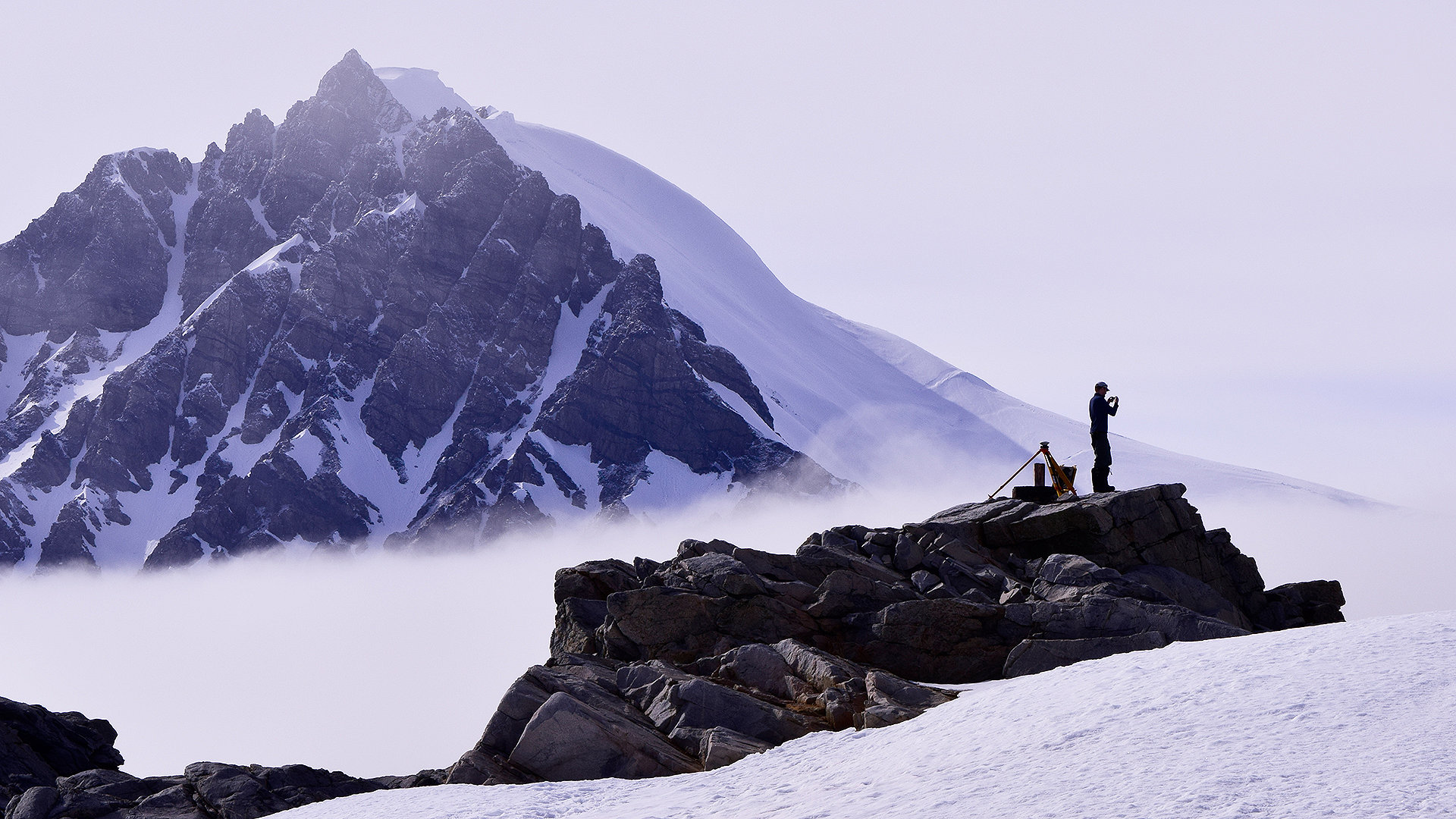 Silhouette of a man stood on snowy mountains