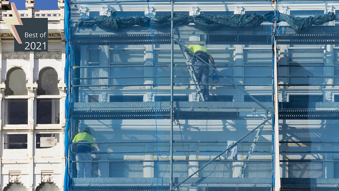construction workers in scaffolding on the building facade for restore, repair and renovate
