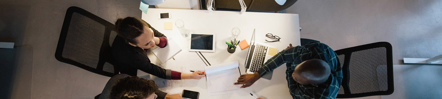 Office workers gather around a table to do research and implement new ideas. High angle view of multi-ethnic business people discussing in board room meeting; Shutterstock ID 273429152; purchase_order: N/A; job: Website Update March 22; client: RICS_PP; other: 