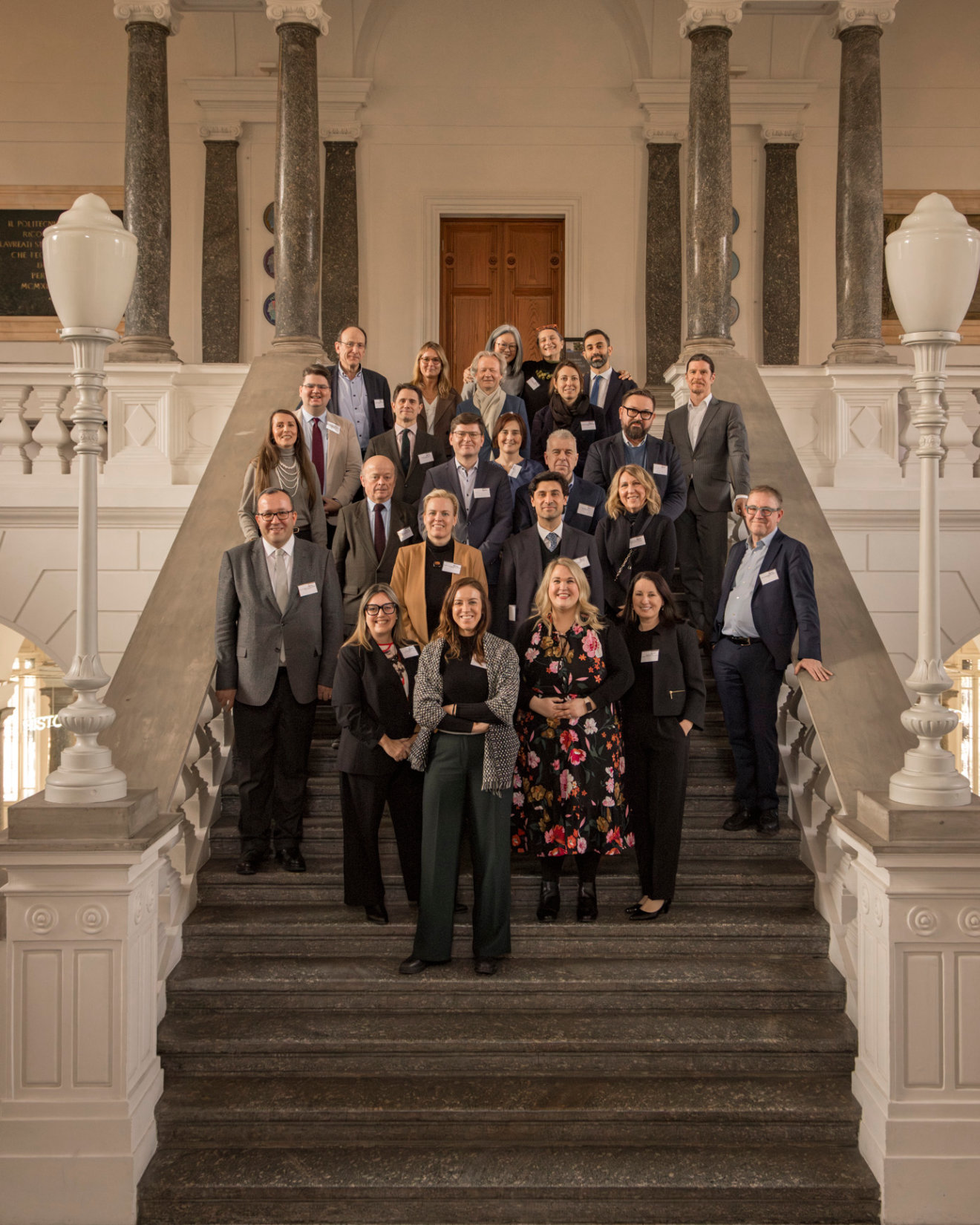 A group of attendees at the RICS European Education Forum 2026 during a discussion. Other groups are shown having discussions in the background,.