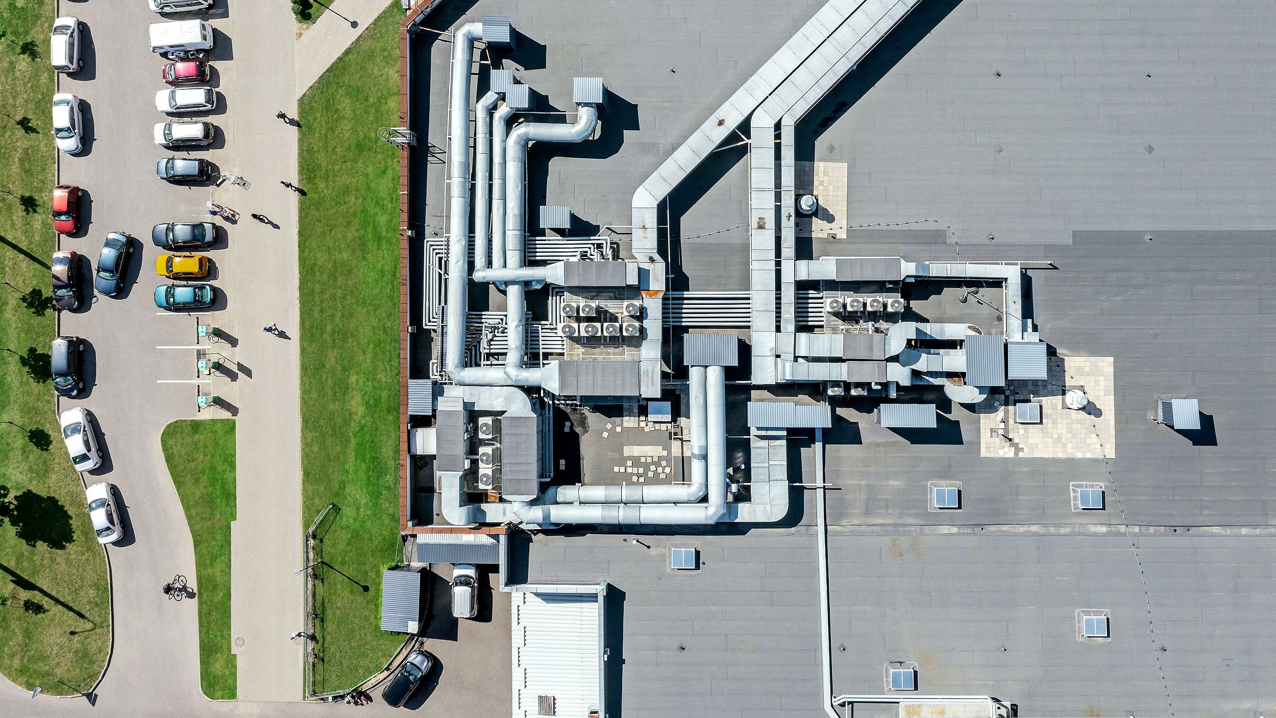 Overhead image of hvac system on supermarket roof with cars park to the left of building