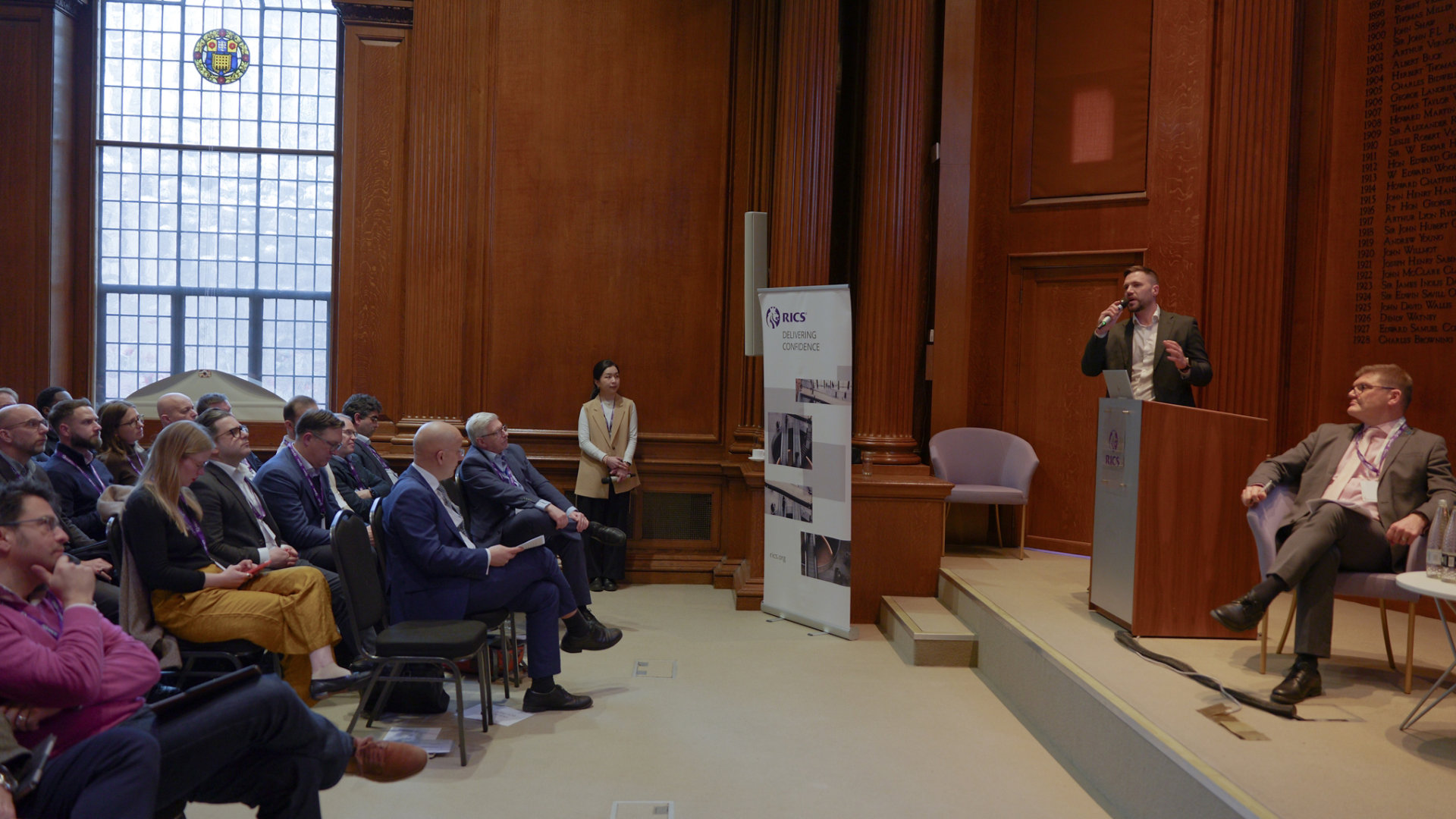 Attendees at the RICS HQ for the Quality in Retrofit Summit watching a panellist speak