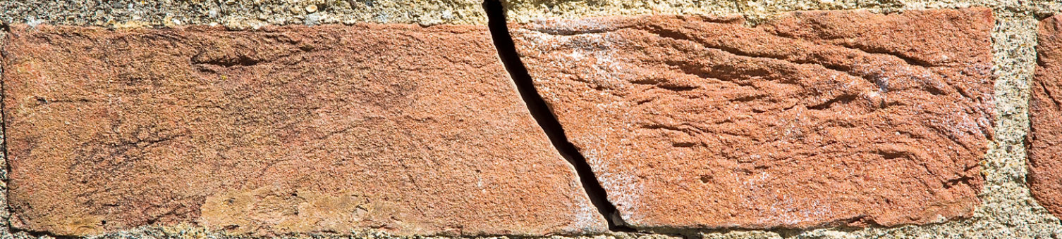 Dangerous old exposed brick wall with deep crack due to structural foundation failure, soil subsidence, corrosion and deterioration of building materials, Climate and seasonal changes, earthquake 