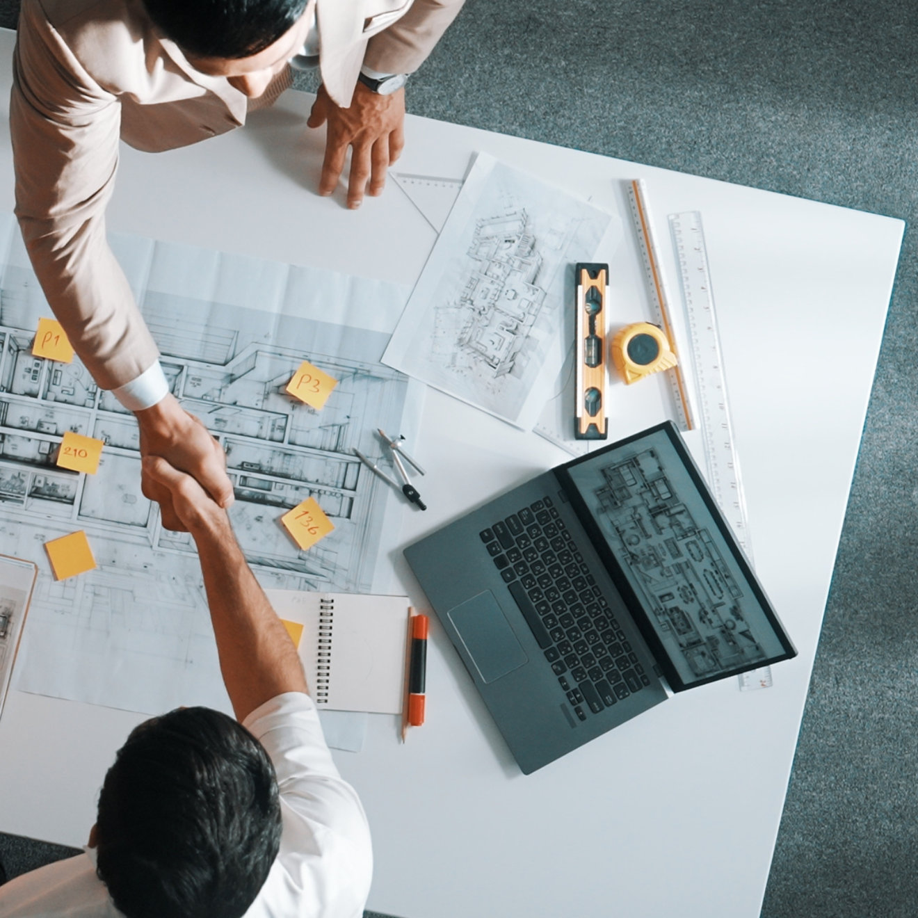 Top down aerial view of architect engineer team shake hands and discussing about building construction. Group of diverse people working together to plan and design by using blueprint. Alimentation.