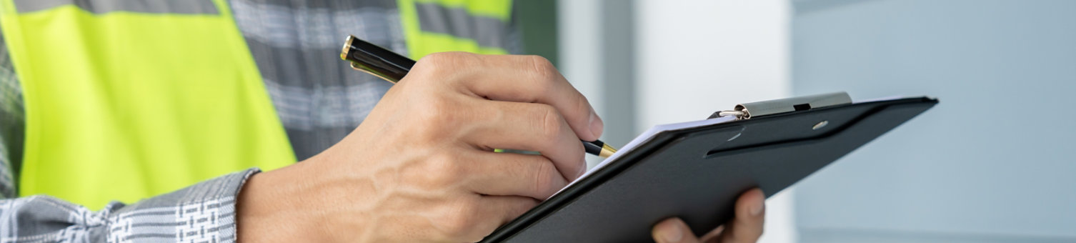 Hands writing on a clipboard