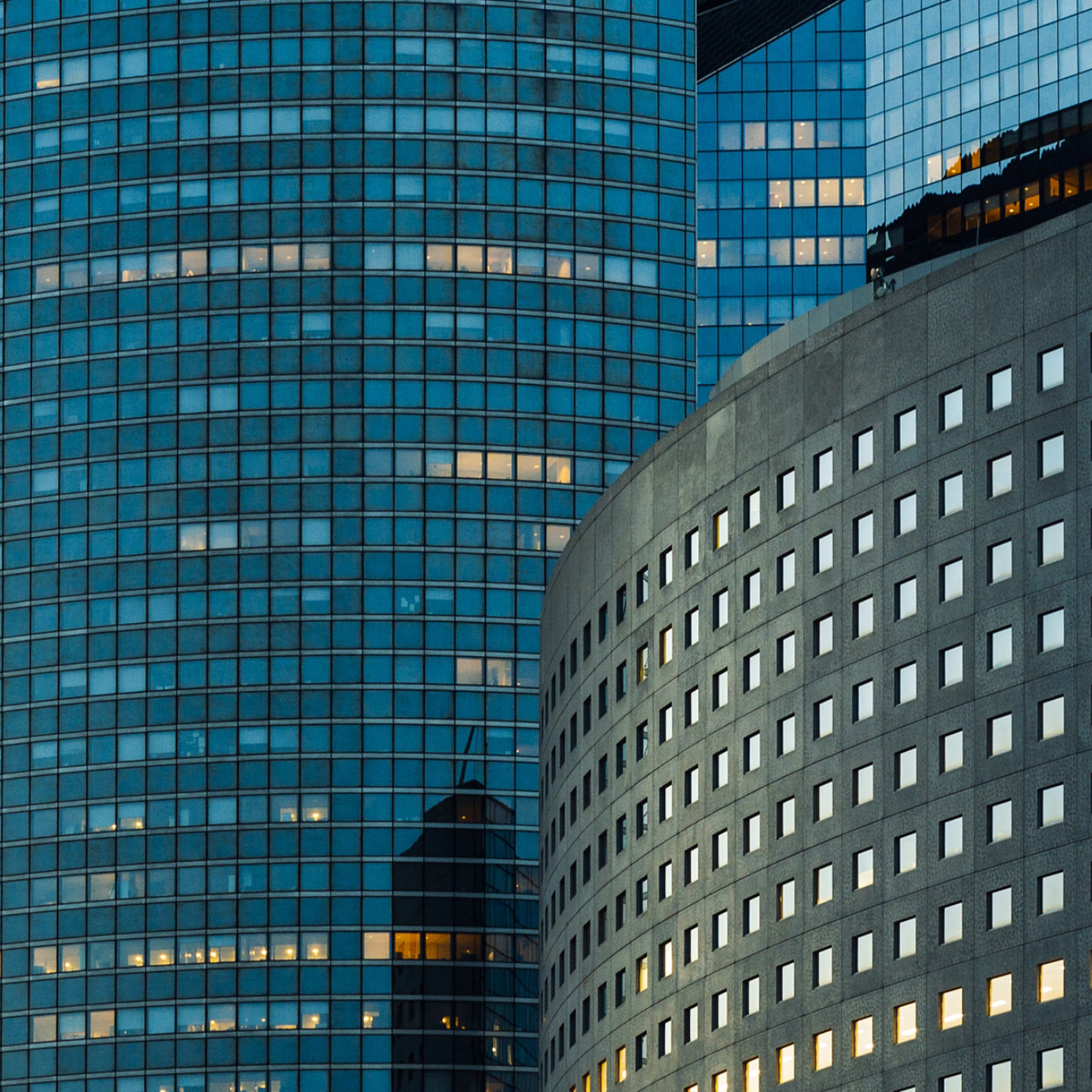 Night architecture - skyscrapers with glass facade. Modern buildings in Paris business district. Evening dynamic traffic on a street. Concept of economics, financial.  Copy space for text. Toned