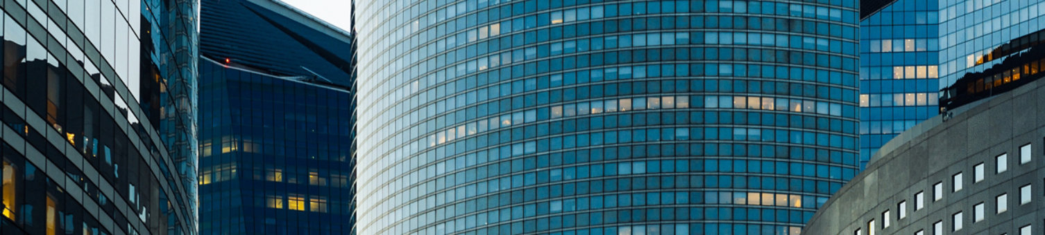 Night architecture - skyscrapers with glass facade. Modern buildings in Paris business district. Evening dynamic traffic on a street. Concept of economics, financial.  Copy space for text. Toned